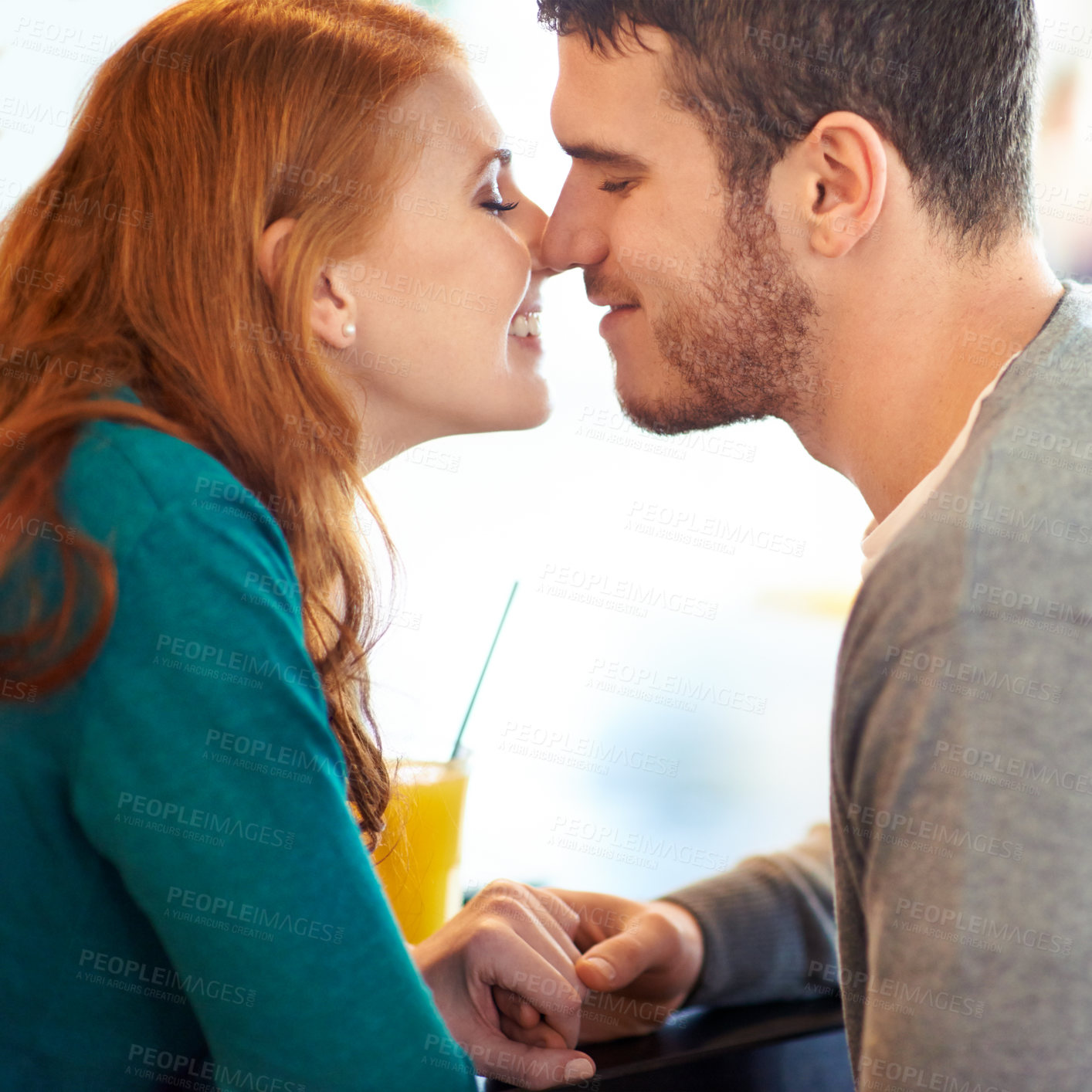 Buy stock photo Couple, date and kiss with love, coffee shop or restaurant with happiness together. Man, woman and romance for relationship, care and smile for flirting on break for relax or bonding in cafe