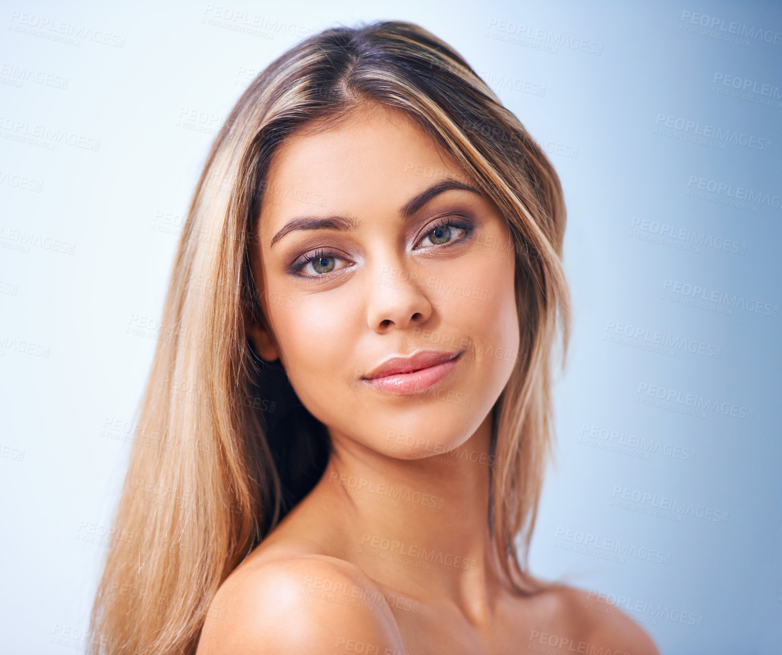 Buy stock photo Studio shot of a beautiful young woman against a blue background