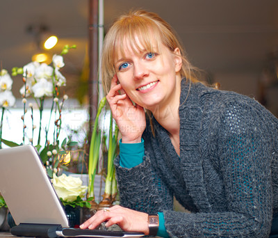 Buy stock photo Portrait of a young woman using a laptop at her place of business