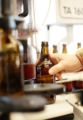 Buy stock photo Hands, beer and bottle in factory, brewery or manufacturing plant for quality inspection. Alcohol, production line and person taking glass from automatic conveyor machine with product in warehouse.