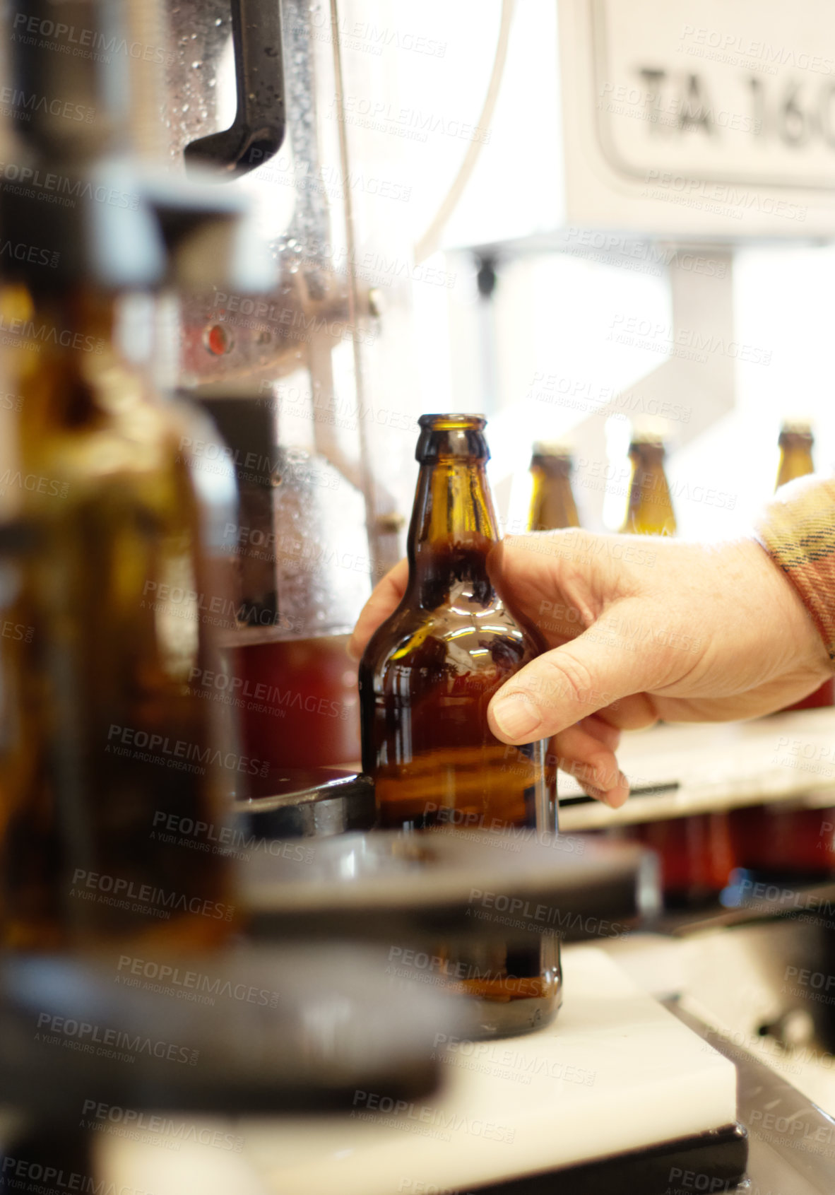 Buy stock photo Hands, beer and bottle in factory, brewery or manufacturing plant for quality inspection. Alcohol, production line and person taking glass from automatic conveyor machine with product in warehouse.