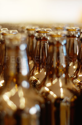 Buy stock photo Closeup, row and beer bottles at a factory for manufacturing, produce and small business. Recycling, glass and empty bottle collection for zero waste, reuse and environmental, waste and prevention