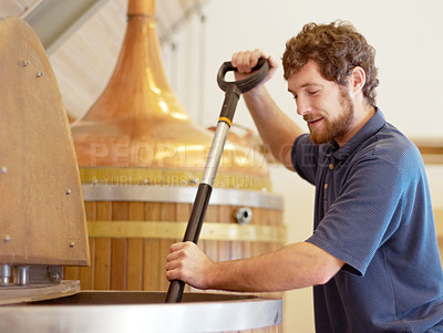 Buy stock photo Shot of a young man working on a batch of beer in a brewery