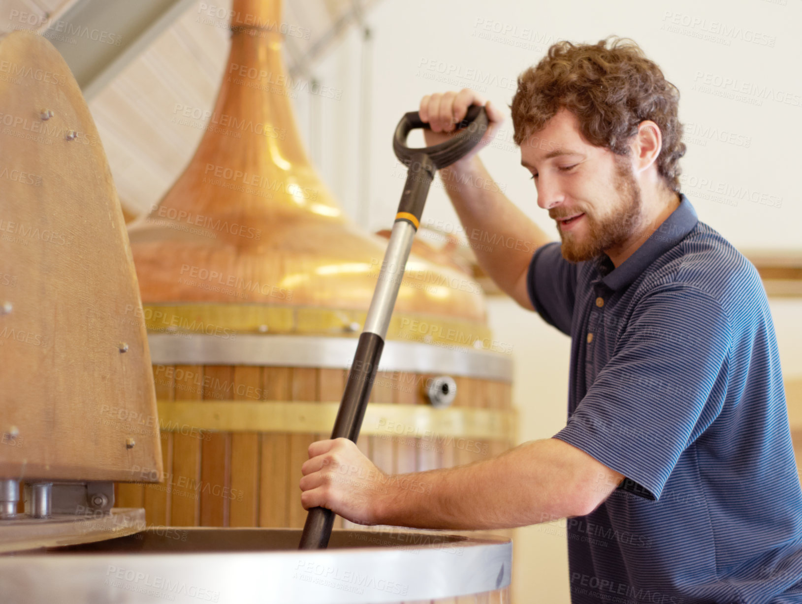 Buy stock photo Shot of a young man working on a batch of beer in a brewery