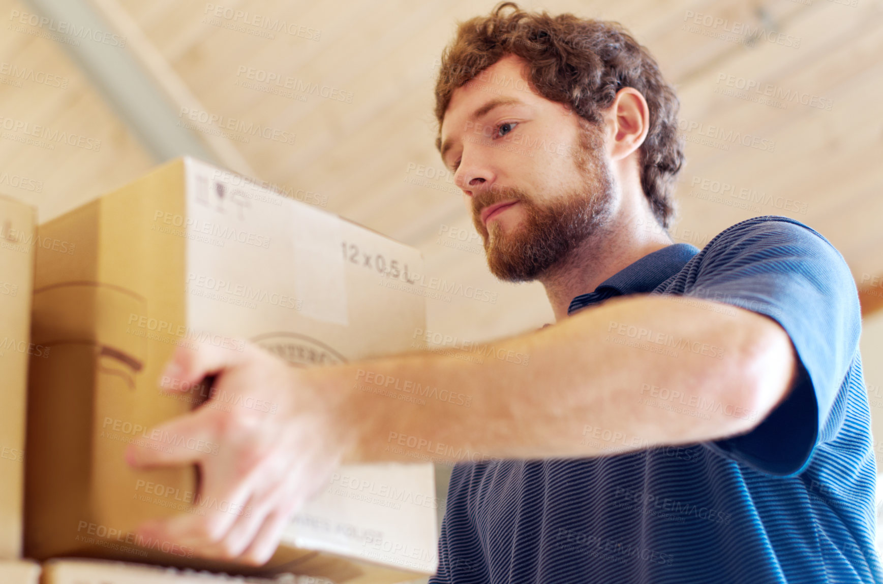 Buy stock photo Shot of a young man stacking boxes