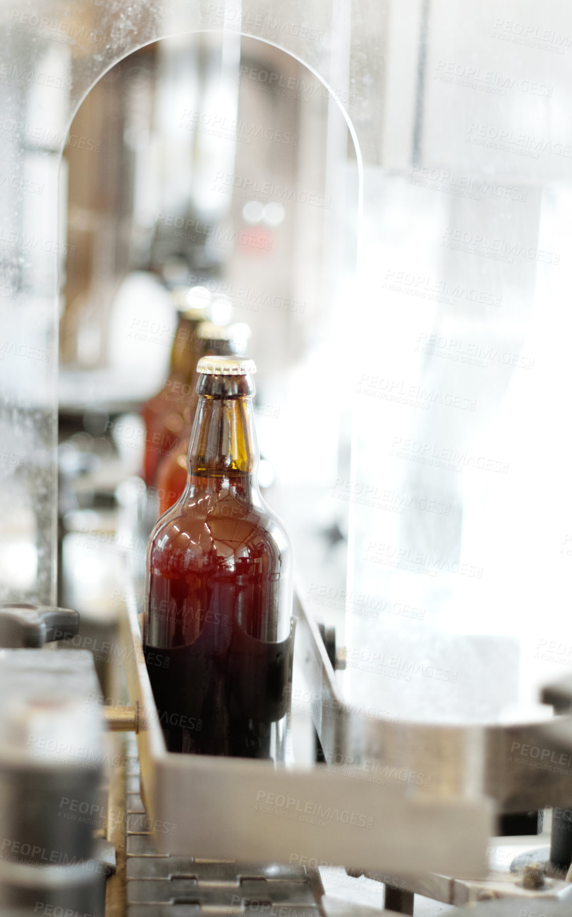 Buy stock photo Shot of beer bottles on a production line at a brewery