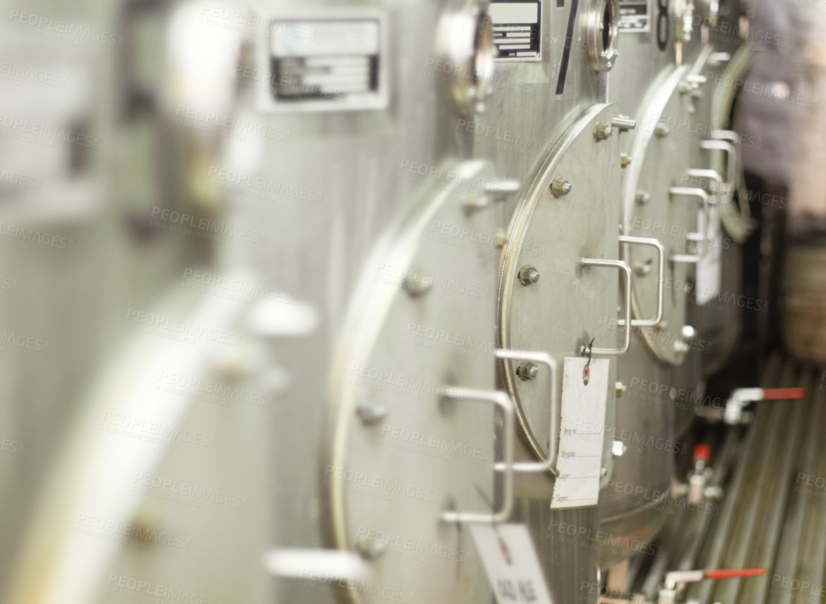 Buy stock photo Closeup, stainless steel and fermentation tanks for brewing beer at a breweries, factory or warehouse. Alcohol, machine and barrel at a manufacturing plant for process, fermentation and procedure