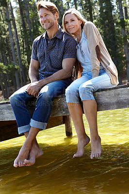 Buy stock photo Couple, lake and happy on pier, nature and sitting with care on vacation, relax or memory in summer. Man, woman and river with smile, trees and bonding with connection for love on holiday in Colorado