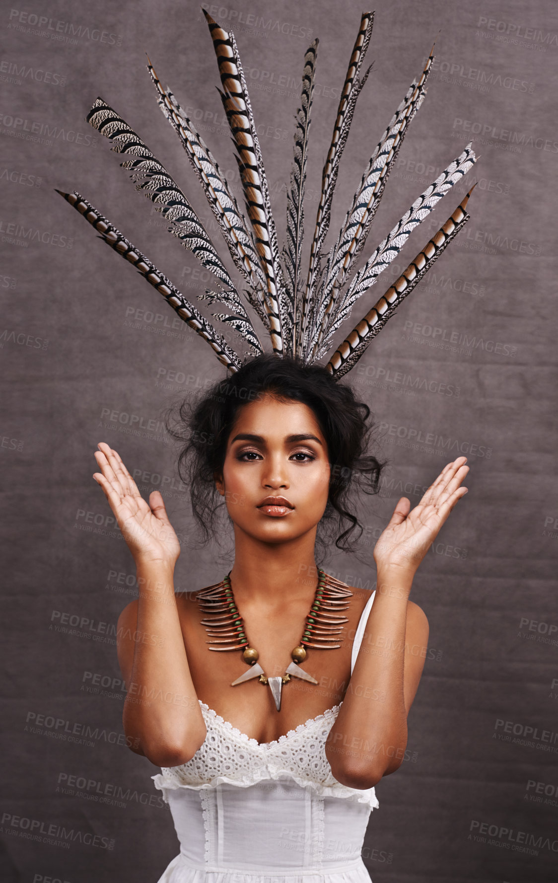 Buy stock photo Indian woman, fashion and feathers with jewelry in studio on black background for heritage or culture. Portrait, female person and confident with traditional necklaces or accessory and hands up