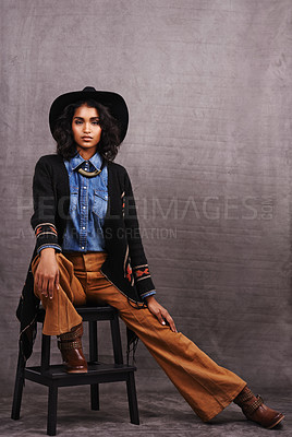 Buy stock photo Portrait, cowgirl or woman in studio, wild west culture and cool fashion in clothing on grey background. Young female person, western lady and stylish model with pride, boho style and chair stool