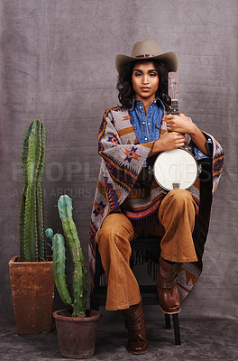 Buy stock photo Portrait, cowgirl or woman with instrument for music in studio and cool fashion or clothing on grey background. Native American person, western and model with plants, boho style and banjo for a song