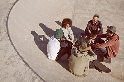 Buy stock photo Shot of a group of friends hanging out in the sun at a skate park