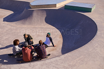 Buy stock photo Shot of a group of friends hanging out in the sun at a skate park