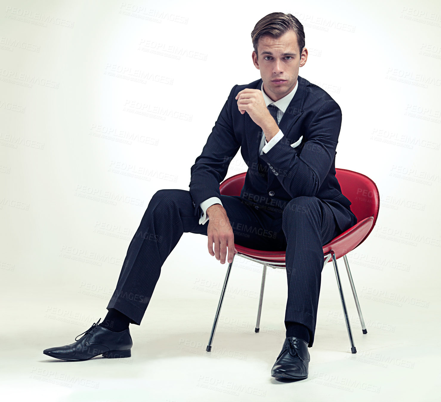 Buy stock photo Portrait, man and vintage suit on chair in studio and serious in formal fashion by white background. Young model, face or confidence in elegant clothes for event, relax or smoking in tuxedo by party