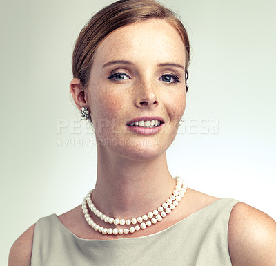 Buy stock photo Portrait, fashion and beauty of young woman in studio isolated on a gray background. Face, freckles and skin of person in vintage clothes for style, retro or elegance with pearl necklace in Ireland