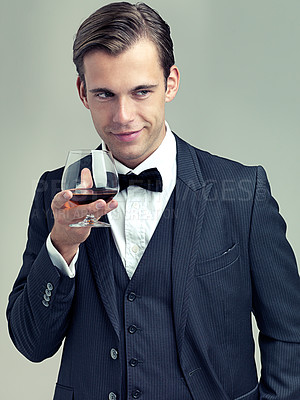 Buy stock photo Glass, whiskey and young gentleman for idea in studio, happy and vintage fashion by white background. Alcohol, drinking and man in retro suit or tuxedo, bow tie and relax in smile at formal event