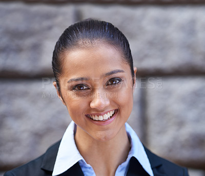Buy stock photo Cropped portrait of a beautiful young businesswoman standing against a wall in the city