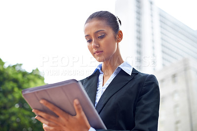 Buy stock photo An attractive young businesswoman using her digital tablet outdoors