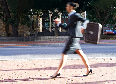 Buy stock photo Motion blurred shot of a businesswoman walking in the city