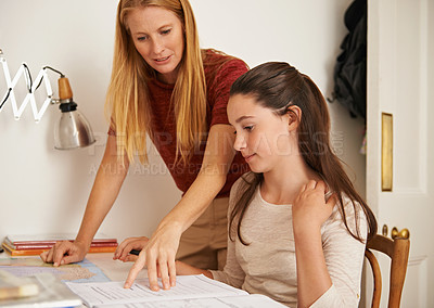 Buy stock photo Shot of a teenage girl getting some studying help from her mother
