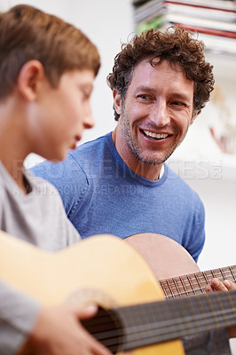Buy stock photo Shot of a father teaching his son the guitar