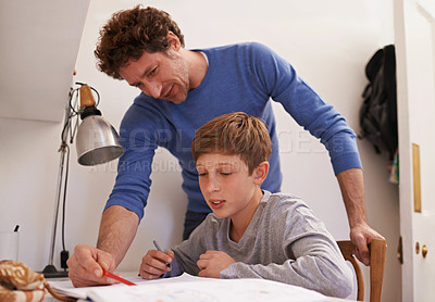 Buy stock photo Shot of a teenage boy getting some study help from his father