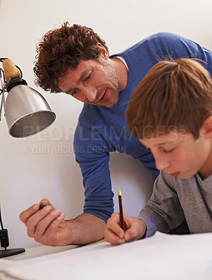 Buy stock photo Study, man and father help son with homework for child, growth and development with education. Parent, guy and male person with support for boy, notebook and writing on table for maths exam or test