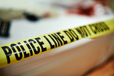 Buy stock photo Shot of police tape with blurred crime scene background