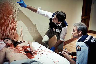 Buy stock photo Cropped shot of two police officers investigating a crimescene