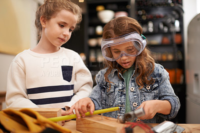 Buy stock photo Shot of a two little girls pretending to be construction workers at home