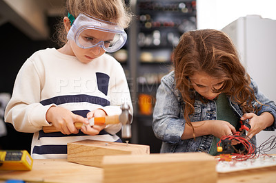 Buy stock photo Children, construction and diy in workshop with tools, play and game in kitchen of home. Girls, hammer and safety glasses for wood project or building, carpentry and woodworking or manufacture