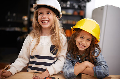 Buy stock photo Shot of two little girls playing around with tools in hard hats