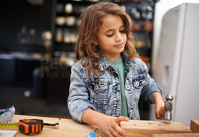 Buy stock photo Girl, carpentry and hammer a nail in workshop, play and game in kitchen of home. Female person, child and equipment or tool for wood project or hobby, construction and remodeling or manufacture