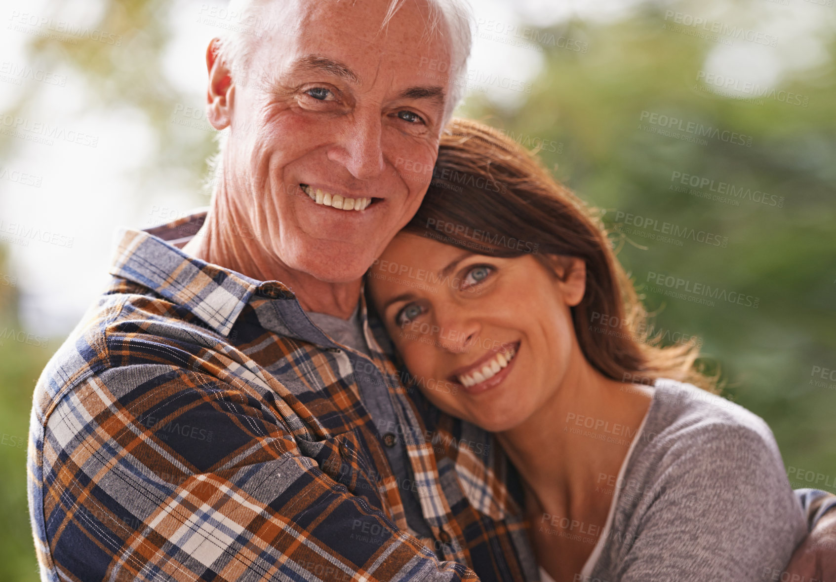 Buy stock photo Senior couple, happy and portrait for hug, love or outdoor in nature with connection for retirement. Woman, elderly man and embrace on patio with pride, care or smile  in backyard by trees in Germany