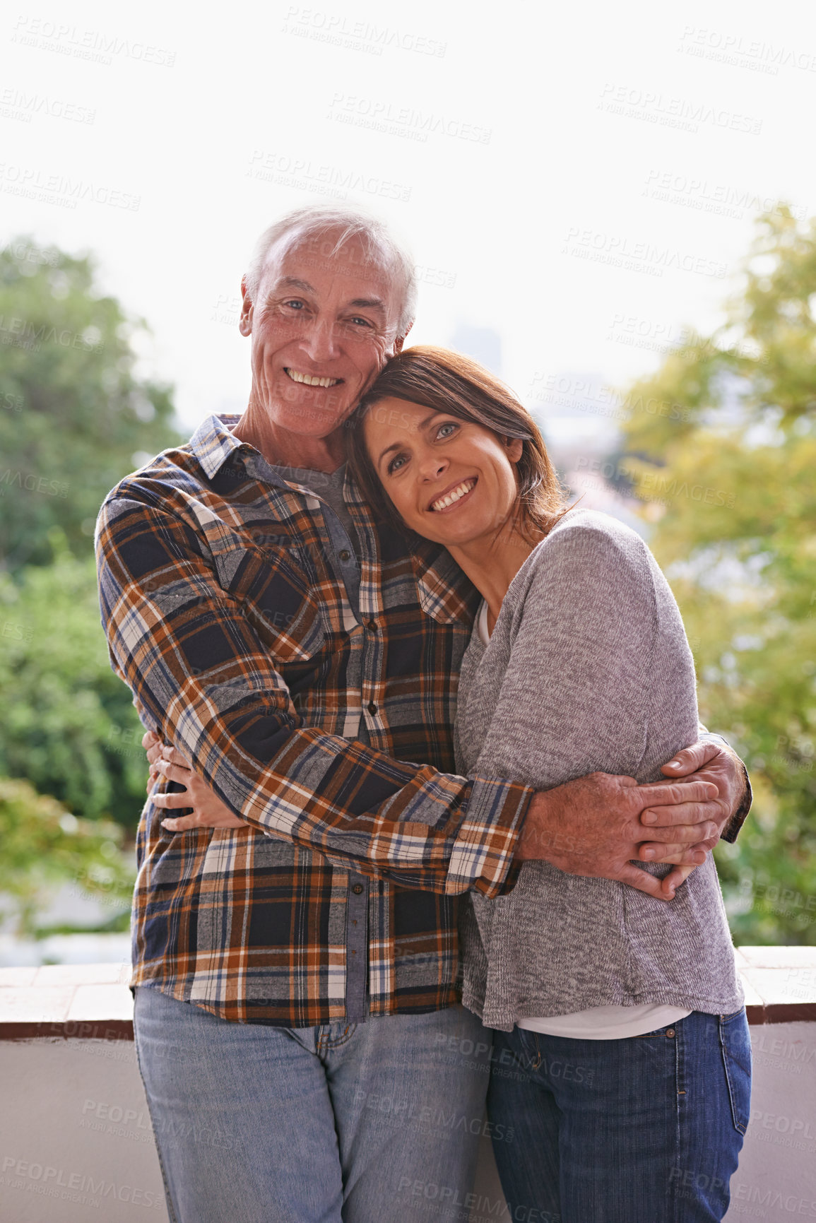 Buy stock photo Senior couple, happy and portrait on balcony with hug, love and outdoor with connection for retirement. Woman, elderly man and embrace on patio with pride, care and smile at apartment in Germany