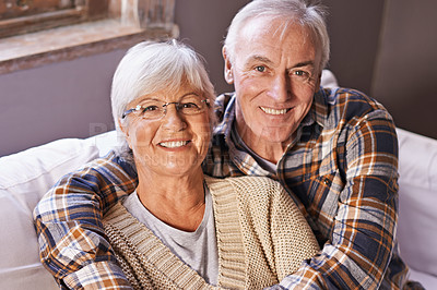 Buy stock photo Senior couple, hug and portrait on sofa with smile, love and connection in living room for retirement. Elderly woman, old man and embrace on couch in lounge with pride, care and happy in apartment