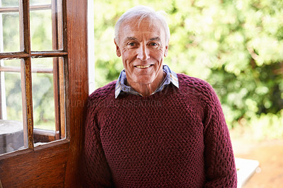 Buy stock photo Portrait of a happy senior man leaning against the doorway to his home