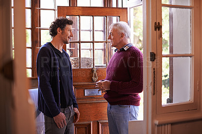 Buy stock photo Son, senior dad and talking in home by front door with advice, chat and bonding with connection. Men, elderly father and adult child with conversation for love, visit and holiday in family house