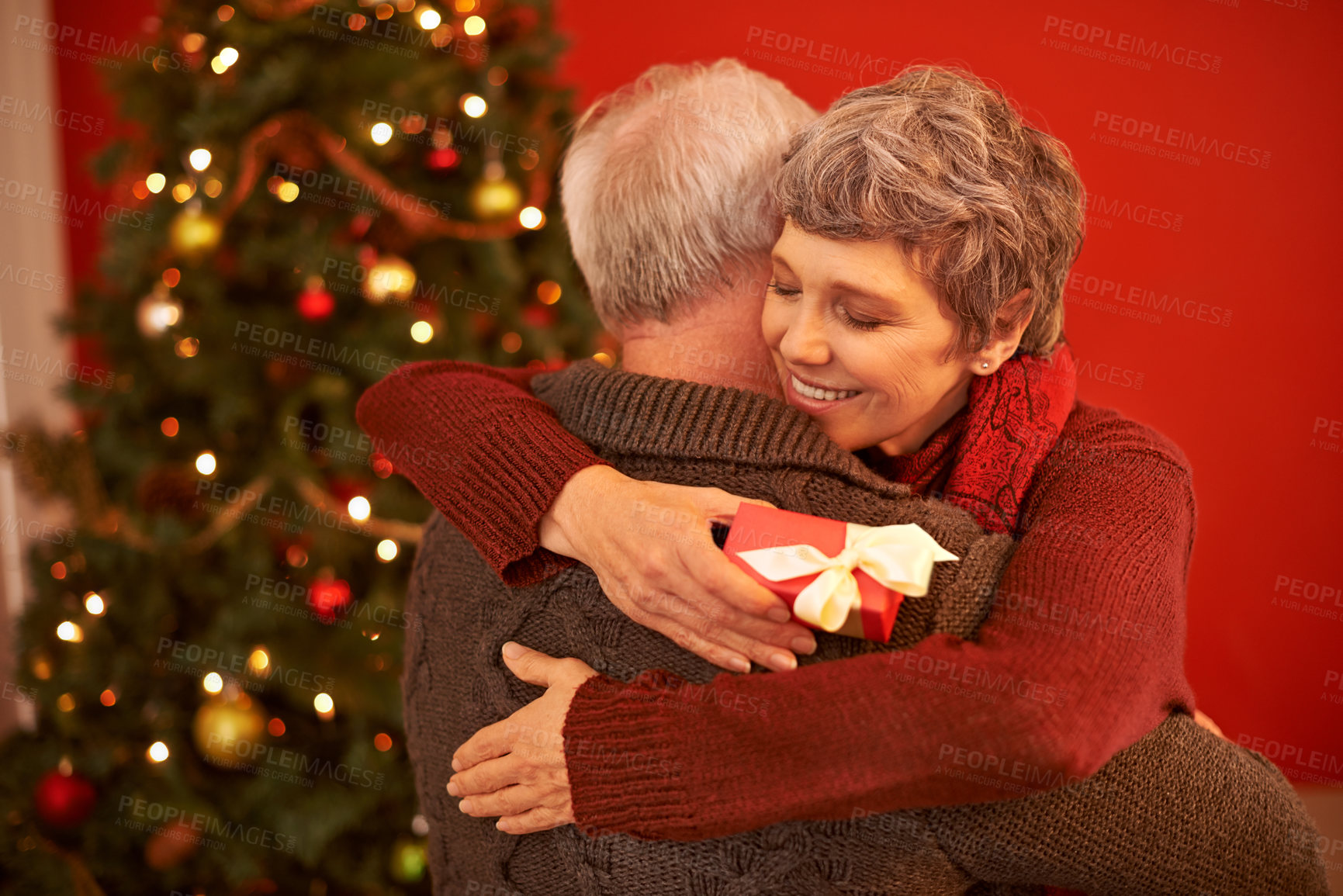 Buy stock photo A cropped shot of a loving senior couple exchanging gifts on Christmas