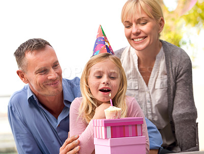 Buy stock photo Child, blow or candle for happy birthday, party or cake as fun wish, family or bonding together. Papa, mama or girl or smile at celebration, congratulations or childhood growth and development