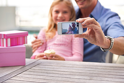 Buy stock photo A cropped shot of a man taking a picture of himself and his young daughter on her birthday