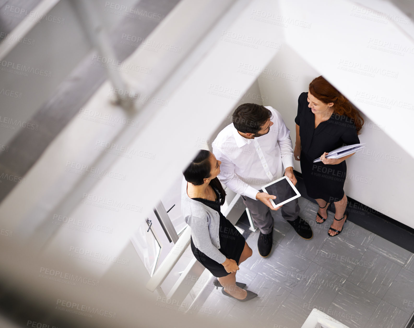 Buy stock photo Office, tablet and business people in stairs together for chat, gossip or discussion with high angle. Work, friends and group of men, women or conversation, secret meeting or team in startup lobby