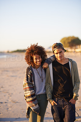 Buy stock photo Shot of a young couple enjoying a walk on the beach