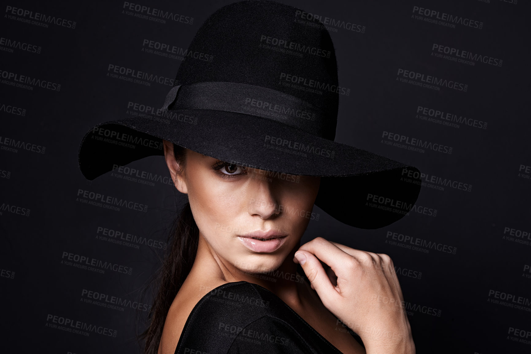 Buy stock photo Woman, portrait and fashion hat with mystery beauty on black background with makeup cosmetics, confidence or stylish. Female person, studio and model or mockup space in America, glamour or formal
