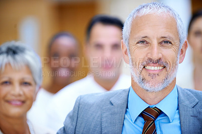 Buy stock photo Portrait of a smiling businessman standing in front of his colleagues