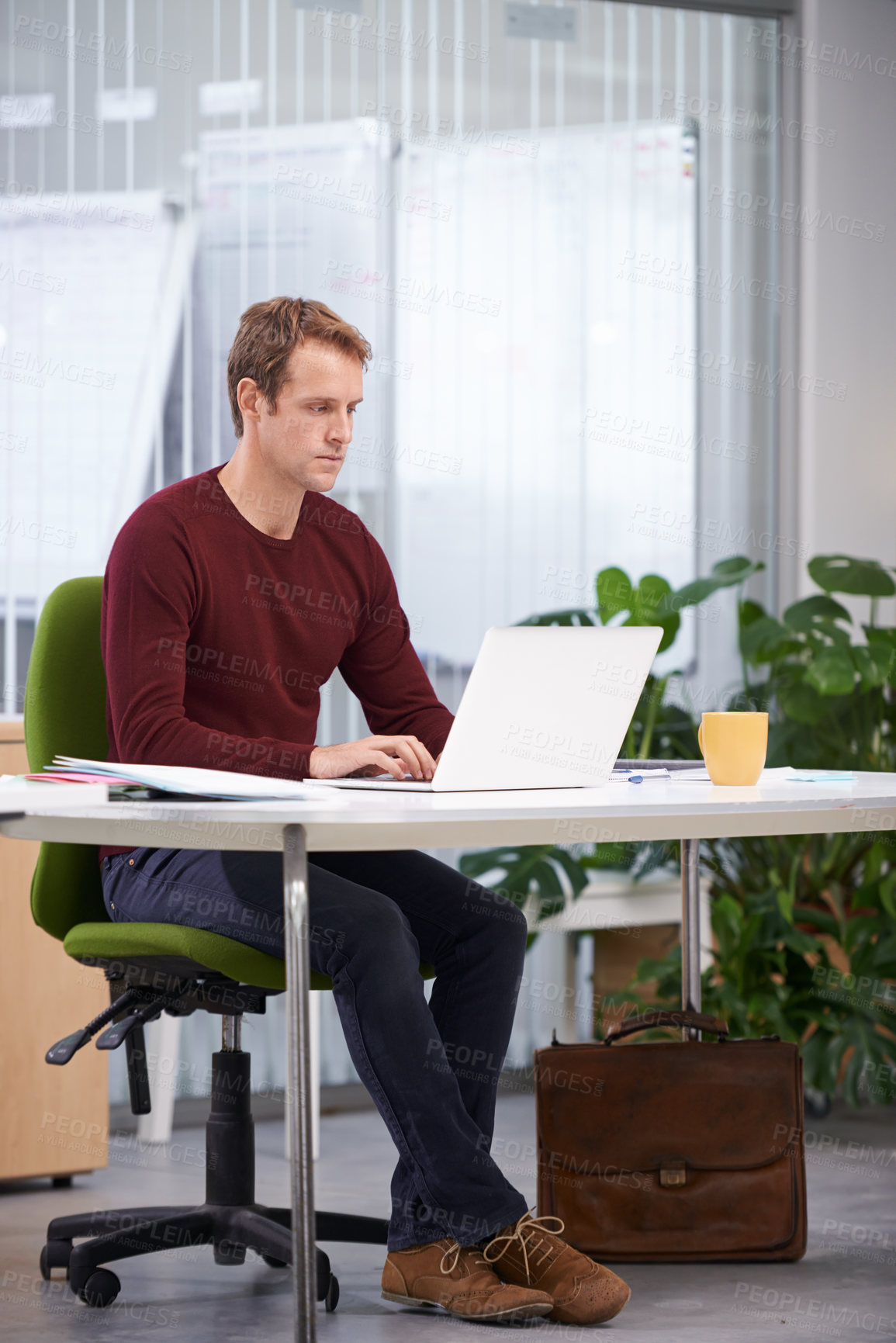 Buy stock photo A handsome businessman working at his desk