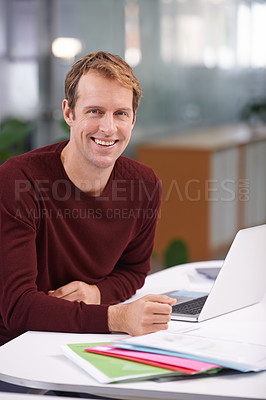 Buy stock photo Man, portrait and research paperwork at laptop or office at creative agency as graphic designer, project or job. Male person, face and smile at desk or small business, entrepreneur or brainstorming