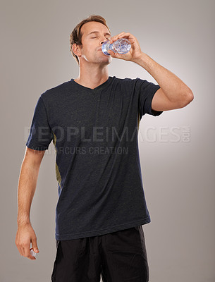 Buy stock photo Healthy, studio or man drinking water for fitness, hydration or workout break isolated on grey background. Tired person, training or thirsty athlete with fresh h2o liquid drink for exercise or detox
