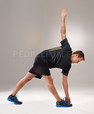 Buy stock photo Man, fitness or training with stretching, mobility or workout as exercise, self care or strength. Runner, athletic person or sportsman in muscle, flexibility or warm-up in studio on grey background