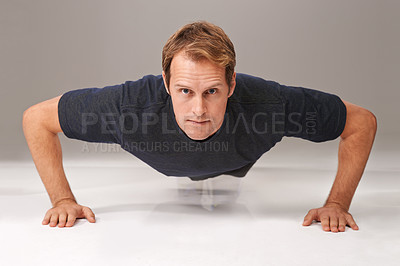 Buy stock photo Man, portrait and push up with fitness or exercise in studio with workout, serious or training with confidence. Athlete, person and physical activity on gym floor for healthy body on white background